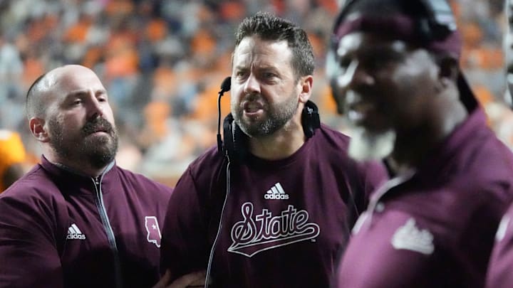Mississippi State Bulldogs defensive coordinator Coleman Hutzler is held back by assistant coach Matt Holecek as yells at officials as on a pass interference call  against the Tennessee Volunteers during the second half at Neyland Stadium.