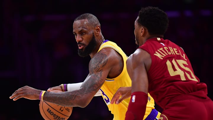 Dec 31, 2024; Los Angeles, California, USA; Los Angeles Lakers forward LeBron James (23) moves the ball against Cleveland Cavaliers guard Donovan Mitchell (45) during the first half at Crypto.com Arena. Mandatory Credit: Gary A. Vasquez-Imagn Images