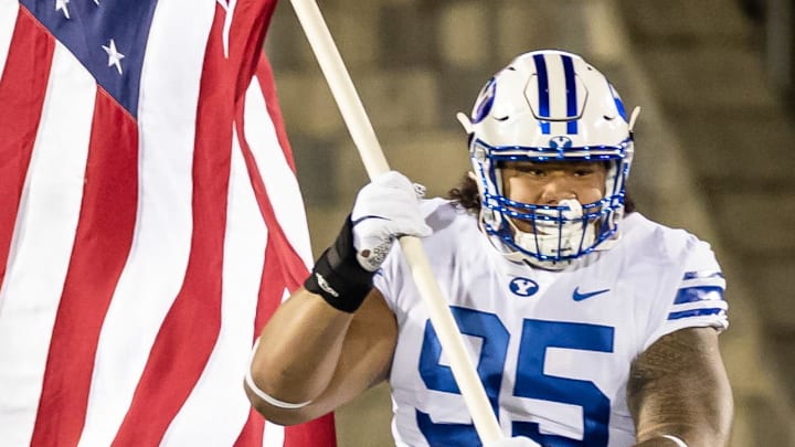 Sep 7, 2020; Annapolis, Maryland, USA; Brigham Young Cougars defensive lineman Khyiris Tonga (95) leads the team onto the field while carrying the American Flag before the game against the Navy Midshipmen at Navy-Marine Corps Memorial Stadium. Mandatory Credit: Scott Taetsch-Imagn Images