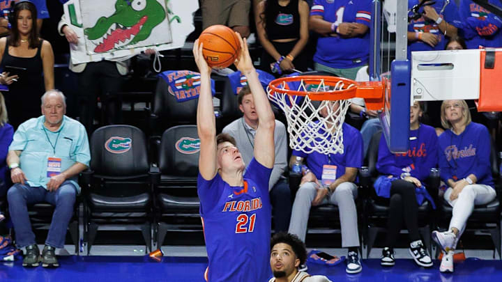 Jan 18, 2025; Gainesville, Florida, USA; Florida Gators forward Alex Condon (21) dunks the ball over Texas Longhorns guard Jordan Pope (0) during the second half at Exactech Arena at the Stephen C. O'Connell Center. Mandatory Credit: Matt Pendleton-Imagn Images