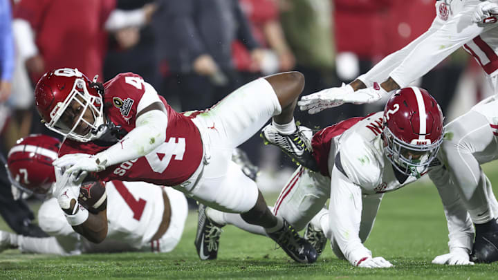 Oklahoma receiver Deion Burks stretches with the football after a catch.