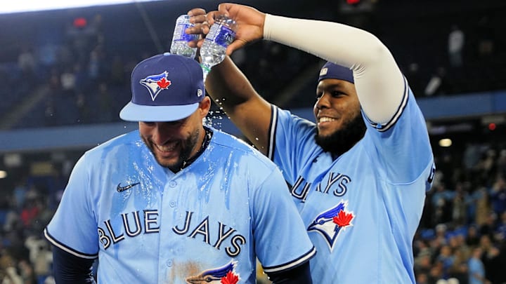 George Springer smiles as first baseman Vladimir Guerrero Jr. pours two small bottles of water on him. George Springer smiles as first baseman Vladimir Guerrero Jr. pours two small bottles of water on him.