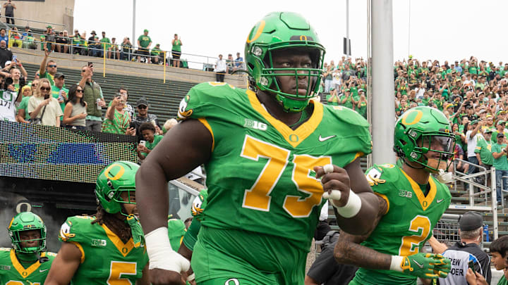 Oregon’s Emmanuel Pregnon, center, takes the field before the game against Oklahoma State at Autzen.