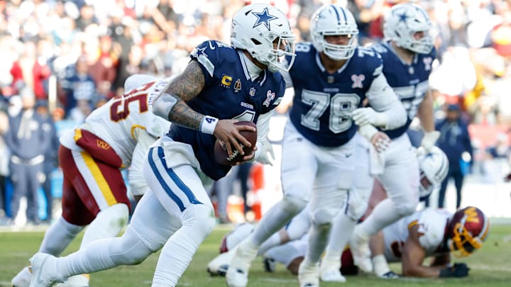 Dallas Cowboys QB Dak Prescott scrambles with the ball, defended by Washington Commanders DT Jer'Zhan Newton.