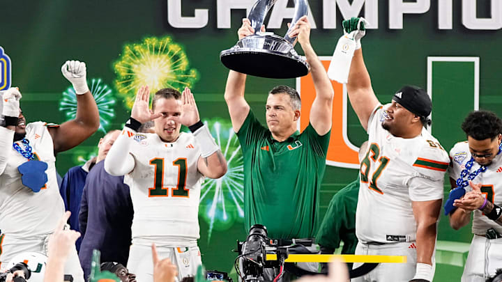 Miami Hurricanes head coach Mario Cristobal hoists the Field Scovell Trophy following the Cotton Bowl at AT&T Stadium in Arlington, Texas for the College Football Playoff quarterfinal game against the Ohio State Buckeyes on Dec. 31, 2025. Ohio State lost 24-14.