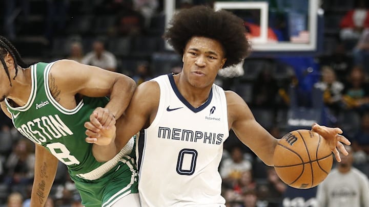 Oct 8, 2025; Memphis, Tennessee, USA; Memphis Grizzlies forward Jaylen Wells (0) dribbles as Boston Celtics forward Josh Minott (8) defends during the third quarter at FedExForum. Mandatory Credit: Petre Thomas-Imagn Images