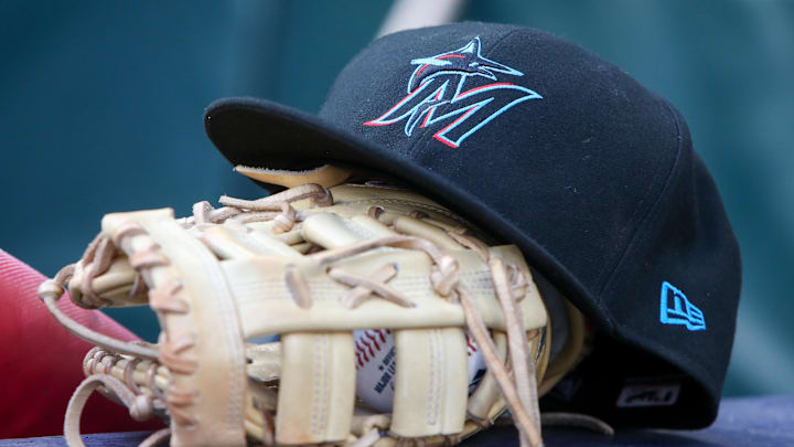 Apr 24, 2024; Atlanta, Georgia, USA; A detailed view of a Miami Marlins hat and glove in the dugout before a game against the Atlanta Braves at Truist Park. 