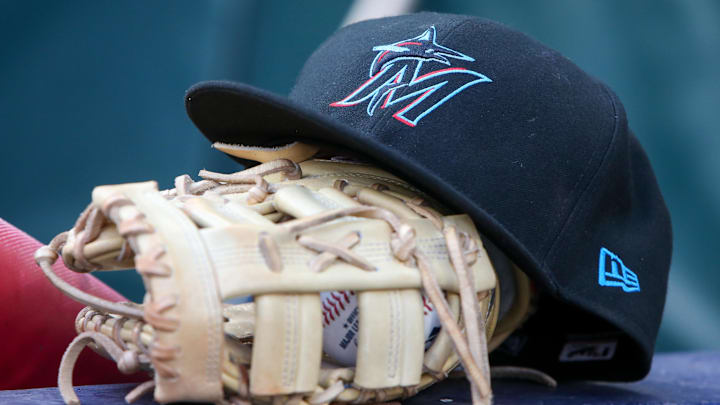 Apr 24, 2024; Atlanta, Georgia, USA; A detailed view of a Miami Marlins hat and glove in the dugout before a game against the Atlanta Braves at Truist Park. 
