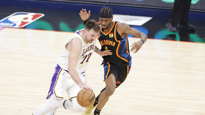 Apr 6, 2025; Oklahoma City, Oklahoma, USA; Los Angeles Lakers guard Luka Doncic (77) drives down the court beside Oklahoma City Thunder guard Shai Gilgeous-Alexander (2) during the second half at Paycom Center. Mandatory Credit: Alonzo Adams-Imagn Images