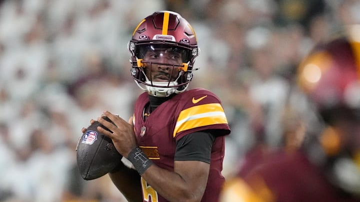 Sep 11, 2025; Green Bay, Wisconsin, USA; Washington Commanders quarterback Jayden Daniels (5) passes in the fourth quarter against the Green Bay Packers at Lambeau Field. Mandatory Credit: Jeff Hanisch-Imagn Images