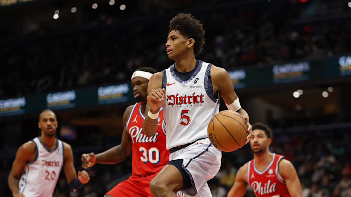 Apr 9, 2025; Washington, District of Columbia, USA; Washington Wizards guard AJ Johnson (5) dribbles the ball as Philadelphia 76ers center Adem Bona (30) defends in the second half at Capital One Arena. Mandatory Credit: Geoff Burke-Imagn Images