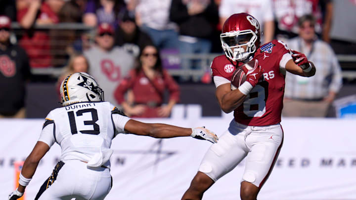 Oklahoma Sooners running back Taylor Tatum (8) carries the ball beside Navy Midshipmen cornerback Andrew Duhart (13) during the Armed Forces Bowl football game between the University of Oklahoma Sooners (OU) and the Navy Midshipmen at Amon G. Carter Stadium in Fort Worth, Texas, Friday, Dec. 27, 2024. Navy won 21-20. Oklahoma Sooners running back Taylor Tatum (8) carries the ball beside Navy Midshipmen cornerback Andrew Duhart (13) during the Armed Forces Bowl football game between the University of Oklahoma Sooners (OU) and the Navy Midshipmen at Amon G. Carter Stadium in Fort Worth, Texas, Friday, Dec. 27, 2024. Navy won 21-20.
