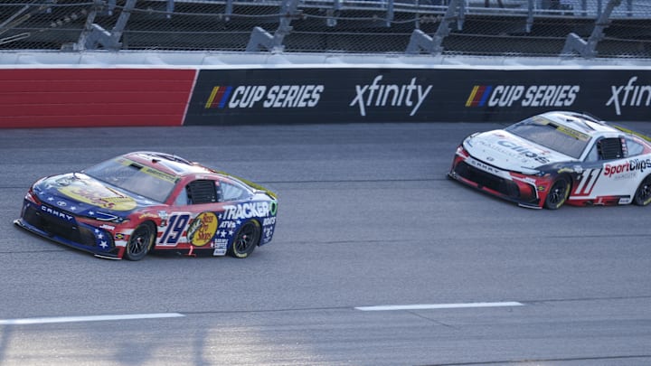 Aug 31, 2025; Darlington, South Carolina, USA; NASCAR Cup Series driver Chase Briscoe (19) leads driver Denny Hamlin (11) out of turn four during the Cookouts Southern 500 at Darlington Raceway.
