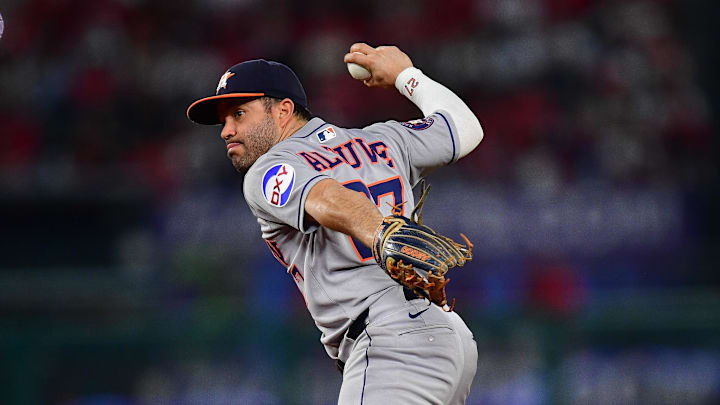 Houston Astros second baseman Jose Altuve (27) throws to first base in a gray uniform and blue hat Houston Astros second baseman Jose Altuve (27) throws to first base in a gray uniform and blue hat
