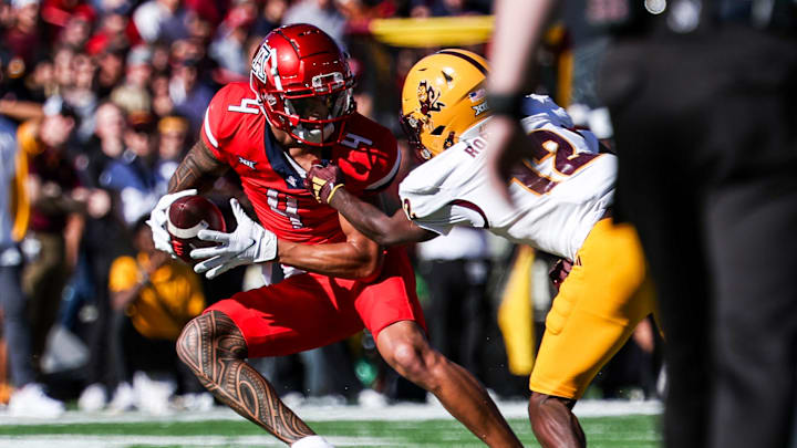 Nov 30, 2024; Tucson, Arizona, USA; Arizona State Sun Devils defensive back Javan Robinson (12) attempts to tackle Arizona Wildcats wide receiver Tetairoa McMillan (4) during the first quarter at Arizona Stadium. Mandatory Credit: Aryanna Frank-Imagn Images