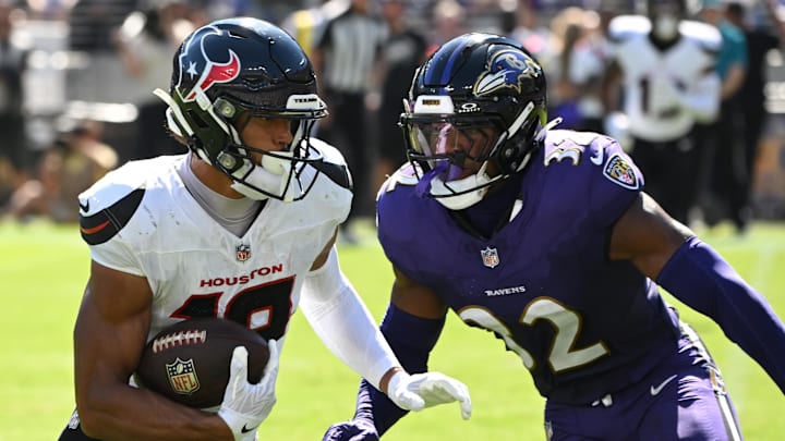 Houston Texans wide receiver Xavier Hutchinson runs for a gain past Baltimore Ravens linebacker Trenton Simpson.