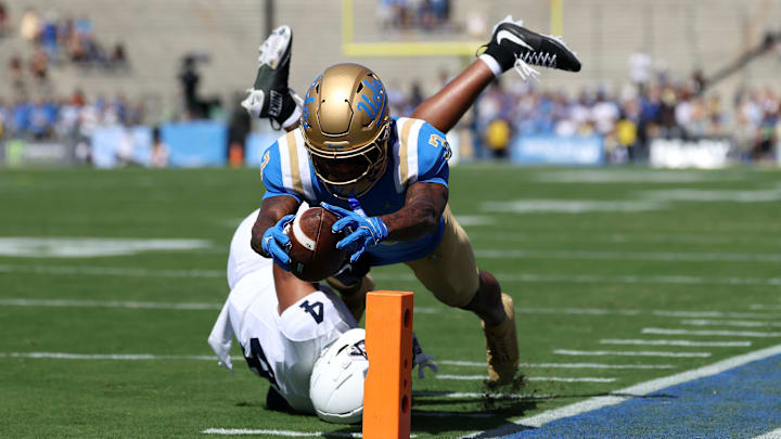Oct 4, 2025; Pasadena, California, USA;  UCLA Bruins wide receiver Kwazi Gilmer (3) scores a touchdown against Penn State Nittany Lions cornerback AJ Harris (4) during the first quarter at Rose Bowl. Mandatory Credit: Kiyoshi Mio-Imagn Images