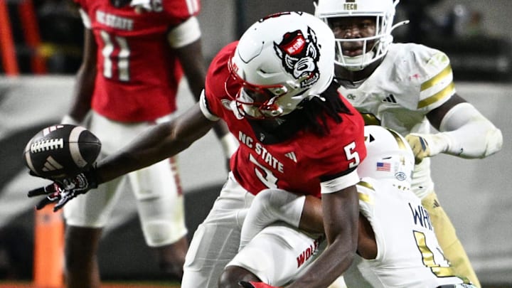 Nov 1, 2025; Raleigh, North Carolina, USA;  North Carolina State Wolfpack wide receiver Noah Rogers (5) loses control of the ball against Georgia Tech Yellow Jackets defensive back Daiquan White (4) during the second quarter at Carter-Finley Stadium. Mandatory Credit: Zachary Taft-Imagn Images