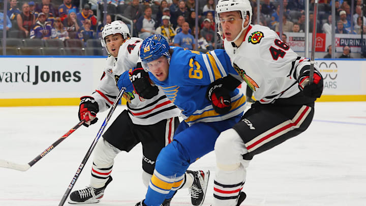 St. Louis Blues F Jake Neighbours engaged in a battle with two opposing skaters
