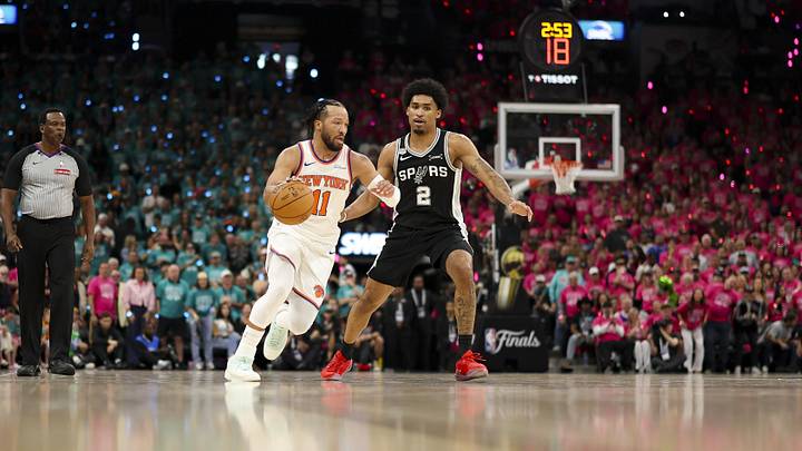 Knicks guard Jalen Brunson brings the ball up court past Spurs guard Dylan Harper in Game 1 of the NBA Finals.