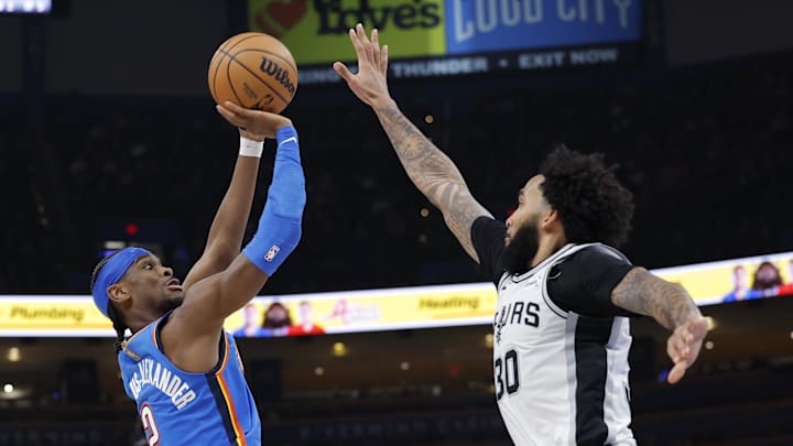 Jan 13, 2026; Oklahoma City, Oklahoma, USA; Oklahoma City Thunder guard Shai Gilgeous-Alexander (2) shoots and scores a basket as San Antonio Spurs forward Julian Champagnie (30) defends during the second half at Paycom Center. Mandatory Credit: Alonzo Adams-Imagn Images