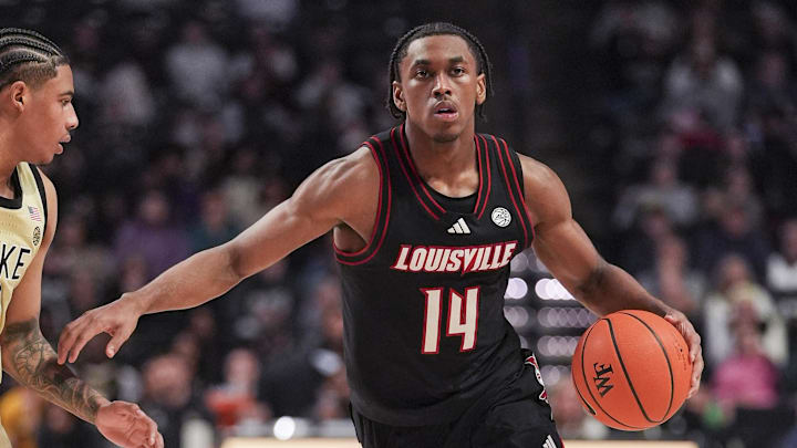 Feb 7, 2026; Winston-Salem, North Carolina, USA; Louisville Cardinals guard Adrian Wooley (14) brings the ball up court against Wake Forest Demon Deacons guard Sebastian Akins (10) during the second half at Lawrence Joel Veterans Memorial Coliseum. Mandatory Credit: Jim Dedmon-Imagn Images