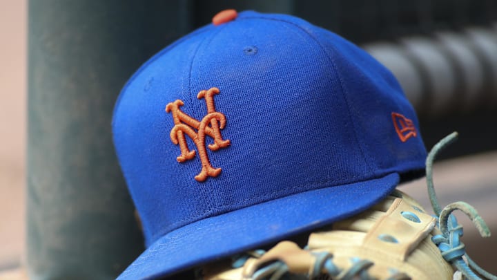 Jul 13, 2022; Atlanta, Georgia, USA; A detailed view of a New York Mets hat and glove in the dugout against the Atlanta Braves in the eighth inning at Truist Park.