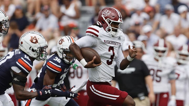 Massachusetts Minutemen quarterback Taisun Phommachanh (3) gets past Auburn Tigers defenders during the first quarter at Jordan-Hare Stadium.