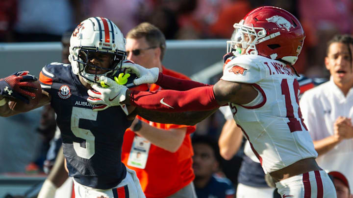 Auburn Tigers wide receiver KeAndre Lambert-Smith (5) is tackled by Arkansas Razorbacks defensive back TJ Metcalf (18) at Jordan-Hare Stadium in Auburn, Ala.