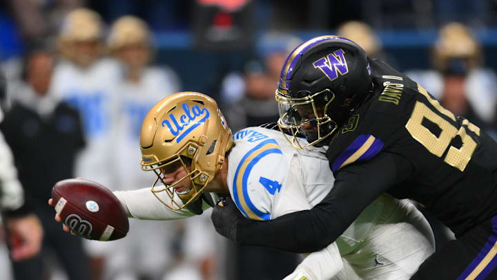 Nov 15, 2024; Seattle, Washington, USA; Washington Huskies defensive lineman Russell Davis II (99) sacks UCLA Bruins quarterback Ethan Garbers (4) during the second half at Alaska Airlines Field at Husky Stadium. Mandatory Credit: Steven Bisig-Imagn Images Nov 15, 2024; Seattle, Washington, USA; Washington Huskies defensive lineman Russell Davis II (99) sacks UCLA Bruins quarterback Ethan Garbers (4) during the second half at Alaska Airlines Field at Husky Stadium. Mandatory Credit: Steven Bisig-Imagn Images