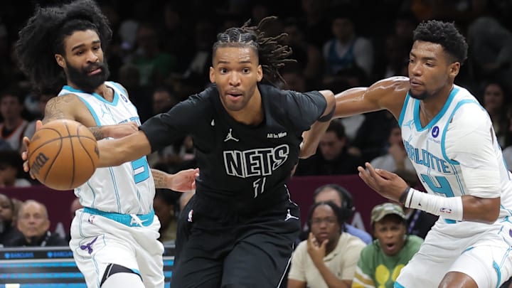 Mar 31, 2026; Brooklyn, New York, USA; Brooklyn Nets forward Ziaire Williams (1) drives to the basket against Charlotte Hornets guard Coby White (3) and forward Moussa Diabate (14) during the first quarter at Barclays Center. Mandatory Credit: Brad Penner-Imagn Images