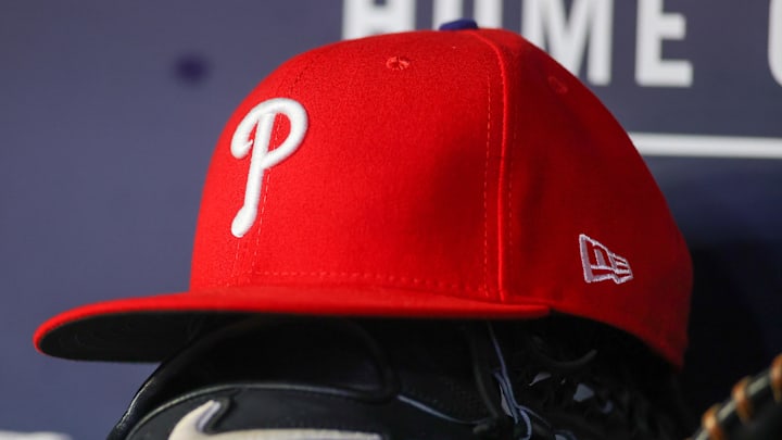 May 26, 2023; Atlanta, Georgia, USA; A detailed view of a Philadelphia Phillies hat and glove on the bench against the Atlanta Braves in the seventh inning at Truist Park. 