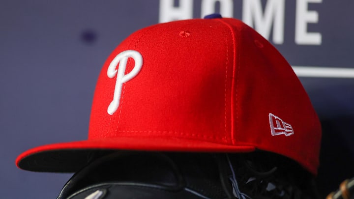 May 26, 2023; Atlanta, Georgia, USA; A detailed view of a Philadelphia Phillies hat and glove on the bench against the Atlanta Braves in the seventh inning at Truist Park. 