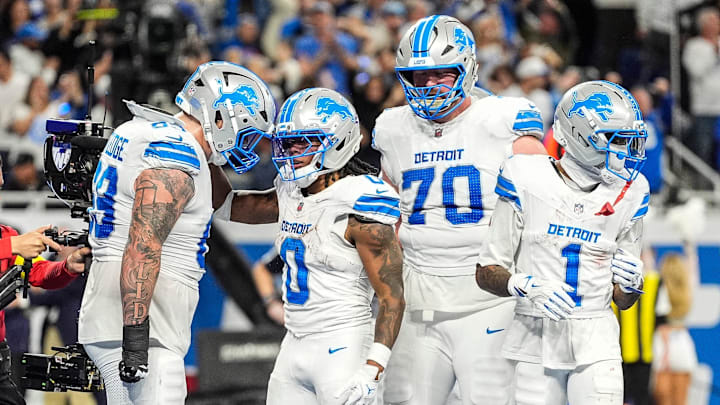 Detroit Lions running back Jahmyr Gibbs (0) celebrates a touchdown against Cownboys with Tate Ratledge (69) 