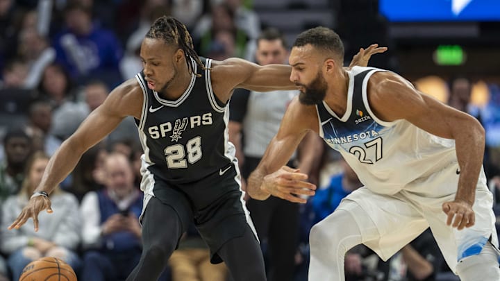 Dec 29, 2024; Minneapolis, Minnesota, USA; San Antonio Spurs center Charles Bassey (28) and Minnesota Timberwolves center Rudy Gobert (27) fight for a loose ball in the first half at Target Center.