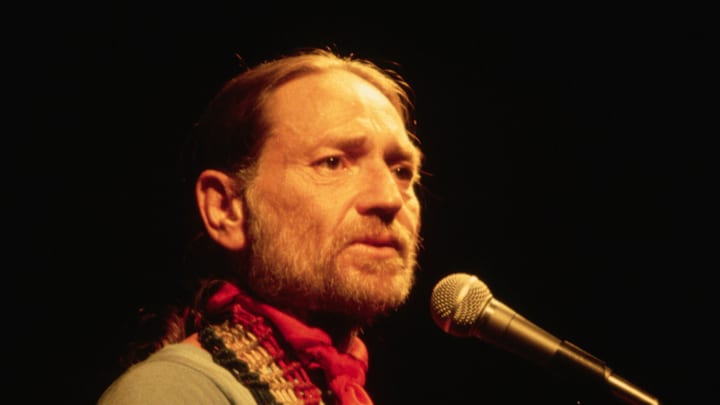 Willie Nelson Sings While Playing the Guitar
