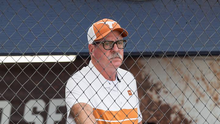 Texas Longhorns head coach Mike White watches the Texas Tech Red Raiders warm up before game one of the NCAA Softball Women's College World Series.