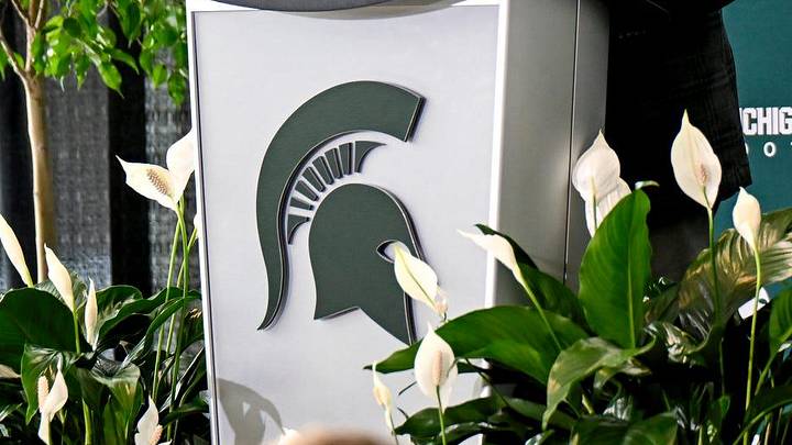 Michigan State University's Athletic Director J Batt, center, speaks as new football coach Pat Fitzgerald, right, and MSU President KevinÊGuskiewicz, left, looks on during an introductory press conference for Fitzgerald on Tuesday, Dec. 2, 2025, at the Tom Izzo Football Building in East Lansing. Michigan State University's Athletic Director J Batt, center, speaks as new football coach Pat Fitzgerald, right, and MSU President KevinÊGuskiewicz, left, looks on during an introductory press conference for Fitzgerald on Tuesday, Dec. 2, 2025, at the Tom Izzo Football Building in East Lansing.