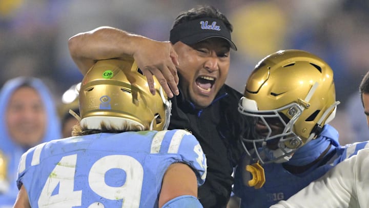 Nov 8, 2024; Pasadena, California, USA;   UCLA Bruins defensive coordinator Ikaika Malloe, center, celebrates with linebacker Carson Schwesinger (49) defensive back Jaylin Davies (6) after an interception in the second half against the Iowa Hawkeyes at the Rose Bowl. Mandatory Credit: Jayne Kamin-Oncea-Imagn Images