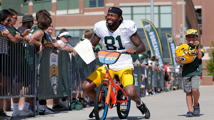 Green Bay Packers wide receiver Julian Hicks rides with a young fan to practice at training camp. Green Bay Packers wide receiver Julian Hicks rides with a young fan to practice at training camp.