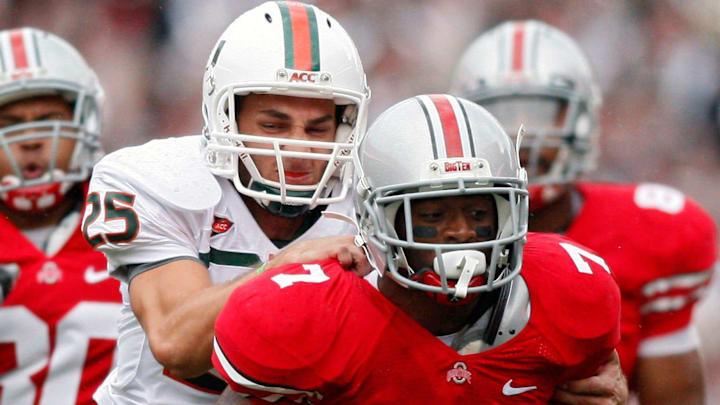 Ohio State running back Jordan Hall (7) gets tackles by Miami (Fl) kicker Matt Bosher (25) during a kick return during the 2nd quarter of their NCAA football game at Ohio Stadium on September 11, 2010.