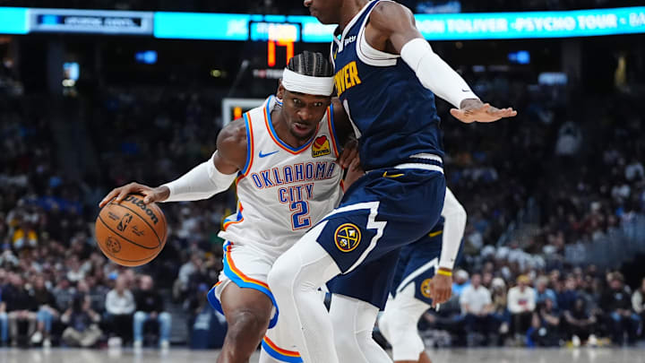 Nov 6, 2024; Denver, Colorado, USA; Oklahoma City Thunder guard Shai Gilgeous-Alexander (2) drives at Denver Nuggets forward Peyton Watson (8)I n the secondquarter at Ball Arena. Mandatory Credit: Ron Chenoy-Imagn Images