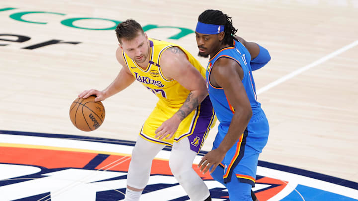 Apr 8, 2025; Oklahoma City, Oklahoma, USA; Los Angeles Lakers guard Luka Doncic (77) moves the ball down the court as Oklahoma City Thunder guard Luguentz Dort (5) defends during the second half at Paycom Center. Mandatory Credit: Alonzo Adams-Imagn Images