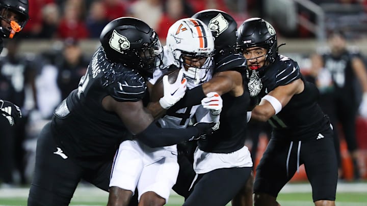 A host of U of L defenders brought down Virginia's Malik Washington (4) during their game at the L&N Stadium in Louisville, Ky. on Nov. 9, 2023. A host of U of L defenders brought down Virginia's Malik Washington (4) during their game at the L&N Stadium in Louisville, Ky. on Nov. 9, 2023.