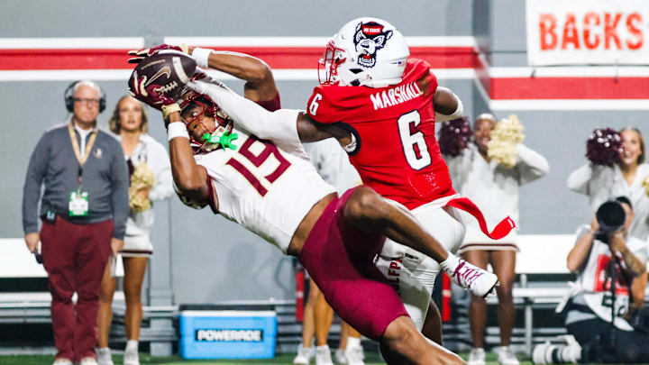 Nov 21, 2025; Raleigh, North Carolina, USA; NC State Wolfpack defensive back Devon Marshall (6) blocks the ball away from Florida State Seminoles wide receiver Micahi Danzy (19) during the first half of the game at Carter-Finley Stadium. Mandatory Credit: Jaylynn Nash-Imagn Images