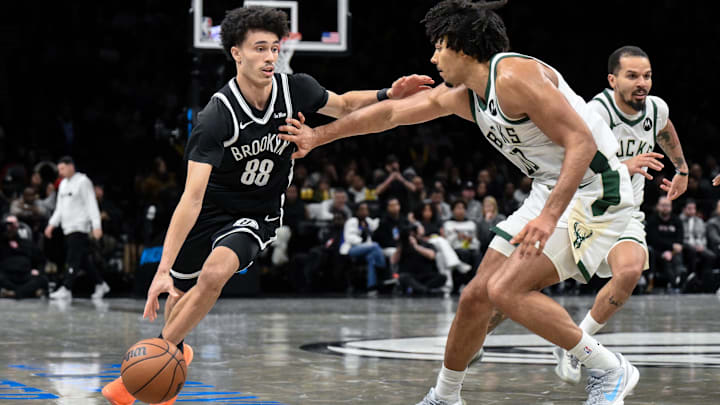 Dec 14, 2025; Brooklyn, New York, USA; Brooklyn Nets guard Nolan Traore (88) drives to the basket defended by Milwaukee Bucks center Jericho Sims (00) during the second half at Barclays Center. Mandatory Credit: John Jones-Imagn Images