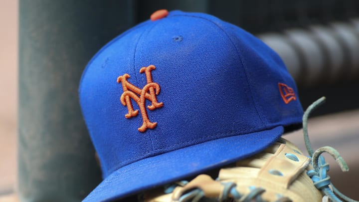 Jul 13, 2022; Atlanta, Georgia, USA; A detailed view of a New York Mets hat and glove in the dugout against the Atlanta Braves in the eighth inning at Truist Park. 