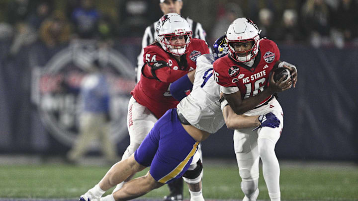 Dec 28, 2024; Annapolis, MD, USA;  East Carolina Pirates defensive lineman J.D. Lampley (9) sacks North Carolina State Wolfpack quarterback CJ Bailey (16) during the first half of the Go Bowling Military Bowl at Navy-Marine Corps Memorial Stadium. Mandatory Credit: Tommy Gilligan-Imagn Images