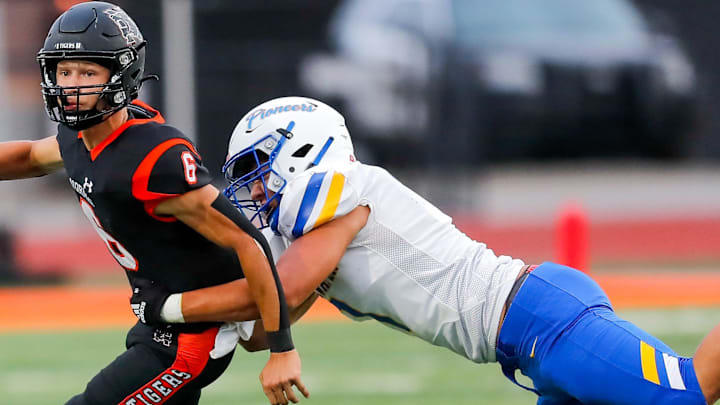 Norman   s Phoenix Murphy (6) is sacked by Stillwater   s Nehemiah Kolone (7) during a high school football game between Stillwater High School and Norman High School in Norman, Okla., on Thursday, Sept. 14, 2023.