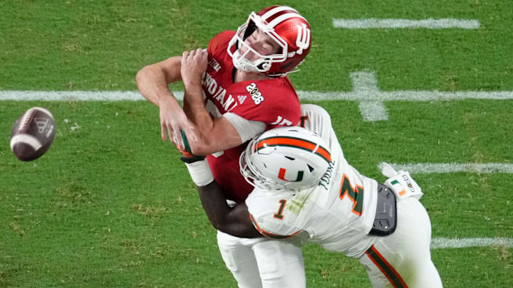Jan 19, 2026; Miami Gardens, FL, USA; Miami Hurricanes linebacker Mohamed Toure (1) hits Indiana Hoosiers quarterback Fernando Mendoza (15) during the first half of the College Football Playoff National Championship game at Hard Rock Stadium. Mandatory Credit: James Lang-Imagn Images